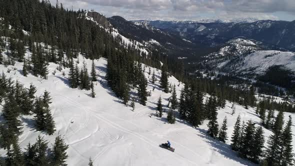 Man Riding Snowmobile on Scenic Mountain Ridge