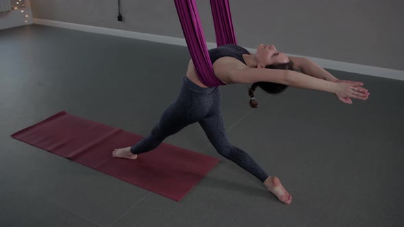 Aerial Yoga  a Young Woman Doing Yoga in Pink Hammock