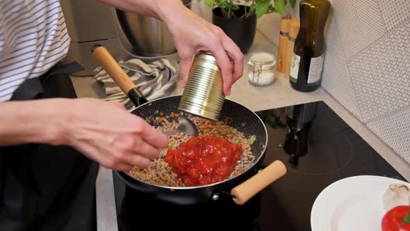 Woman Cooking Sauce Bolognese in Kitchen