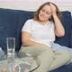 Woman Sits on Sofa and Massages Temples on Head Because of Headache and Drinks Water - VideoHive Item for Sale