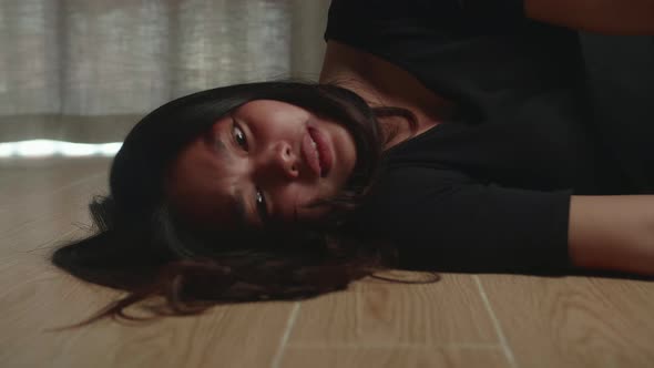 Sad And Depressed Asian Woman Lying On The Floor