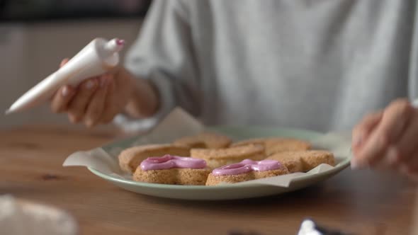 Woman Decorating Cookies with Pink Icing