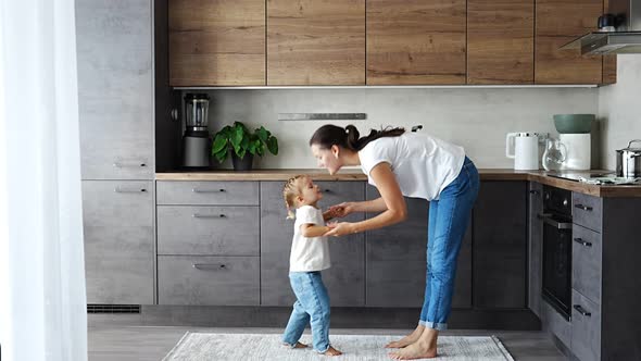 Little Girl and Happy Mother Have a Fun at Home Kitchen