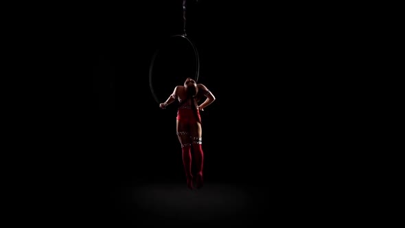 Girln Hanging in Scene for Aerial Acrobatics. Black Background. Slow Motion