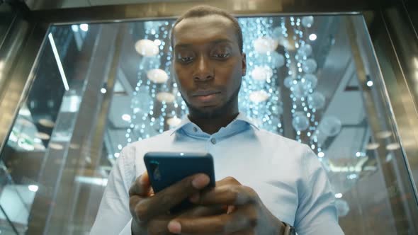 An African American Man Uses a Smartphone To Communicate on the Internet