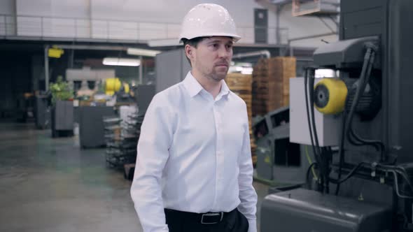 Shot of Professional Factory Worker Wearing Hard Hat Holds Tablet Computer Walking Thorugh Modern