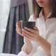 Young woman sitting on the bed and holding cup with drinking coffee in the morning. - VideoHive Item for Sale