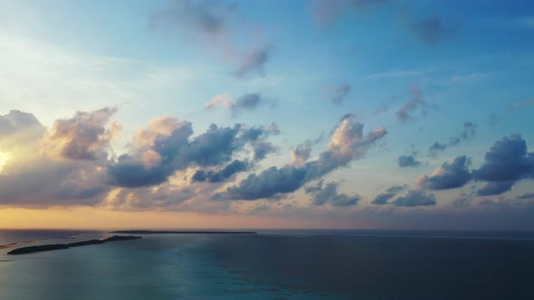 Wide angle drone island view of a white sandy paradise beach and blue sea background in colorful 4K