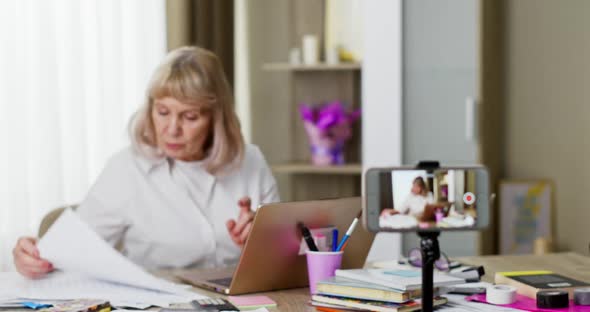 Elderly Lady Doing a Video Conference Call on Her Mobile Phone with the Screen Visible To the Camera