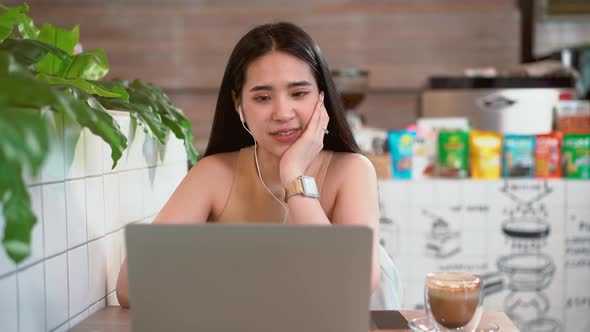 Trendy business female in headphones smiling talking online video call use laptop in online chat 