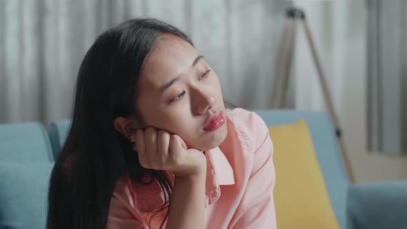 Close Up Of Asian Woman With A Laptop Looking At The Bill And Being Sad While Sitting On Sofa