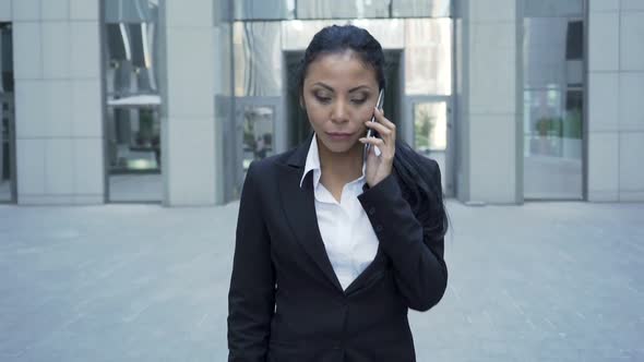 Confident Woman in Business Suit Walking, Holding Phone by Ear, Conversation