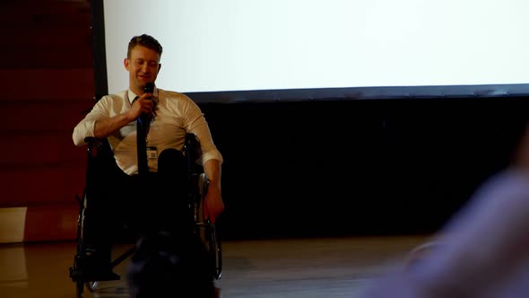 Young Caucasian disabled businessman speaking in business seminar in auditorium 4k