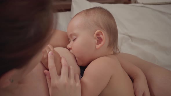 The mother breastfeeds the baby at night