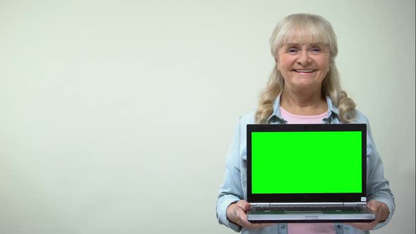 Aged Lady Showing Laptop With Green Screen