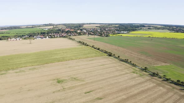 Aerial Drone Shot  a Rural Area with Fields and a Road  a Town in the Background