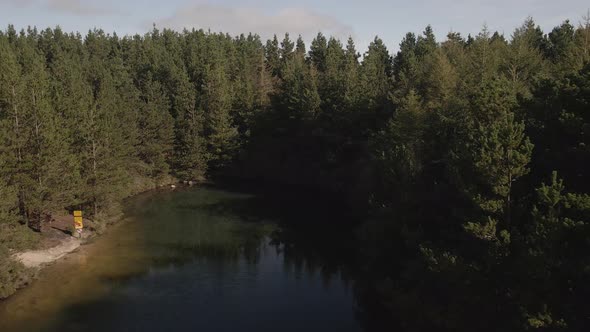 Calm Lake Water Surrounded By Lush Pine Trees At Abandoned Quarry Of Carrigfoyle In Wexford, Ireland