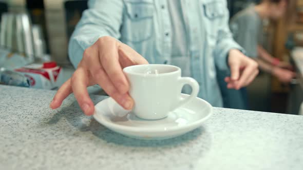 The barista put the finished coffee on the bar counter, and the table in the coffee shop