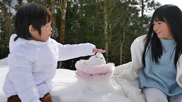 Cute Asian Children Playing With Snowman