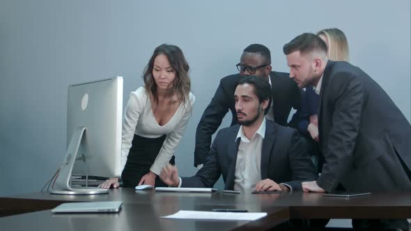 Group of Multiracial Business People Around the Conference Table Looking at Laptop Computer