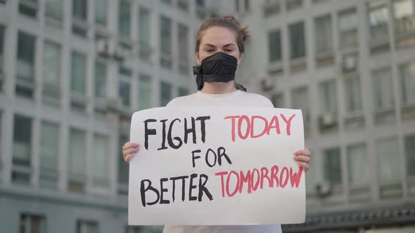 Beautiful Woman in Face Mask Standing in Urban City with Banner and Looking at Camera. Portrait of