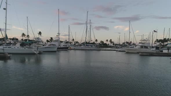 Aerial pullback sailing boats moored on marina during Sunset, Hawaii.