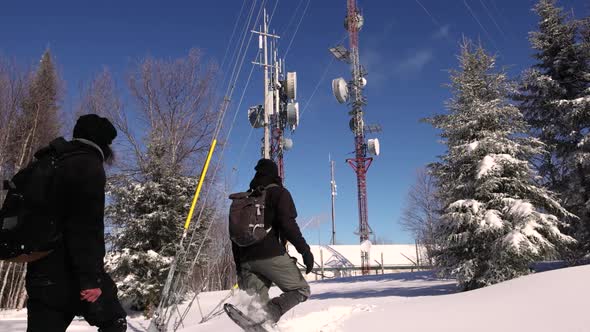 Two Documentarians at Telecommunication Tower Base