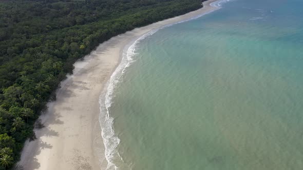 Cape Tribulation aerial tilt backward reveal of sunny beach in Daintree Rainforest, Queensland, Aust