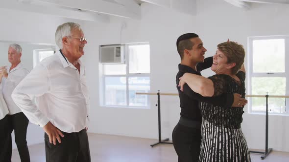 mixed race male dance teacher taking a ballroom dancing class at a dance studio