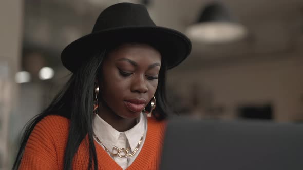 Focused Black Woman Working on Laptop at Cafeteria