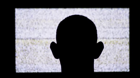Silhouette of a Man's Head in Front of White Noise and TV Interference.
