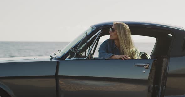 Beautiful woman getting out of a vintage car