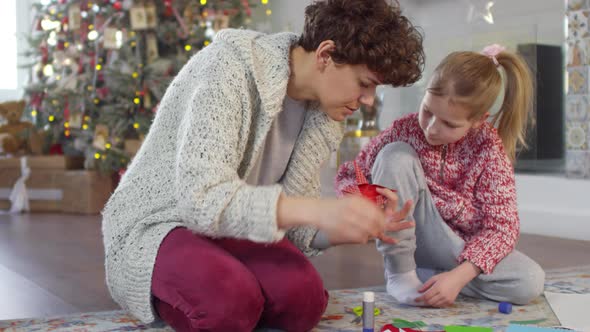 Mother and Little Daughter Making Origami Star for Christmas