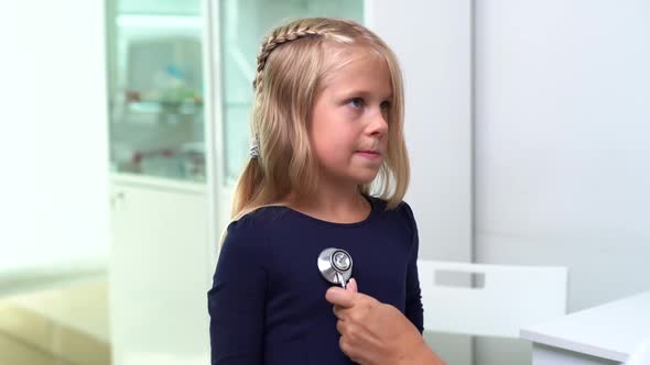 Pediatrician with Stethoscope Examining Young Kid Girl with Blond Hair