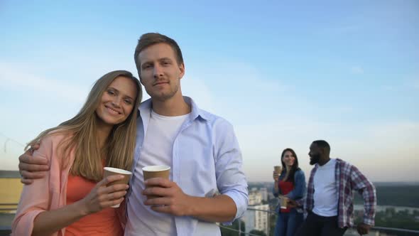 Hugging Caucasian Couple Smiling at Camera, Spending Time Together at Roof Party