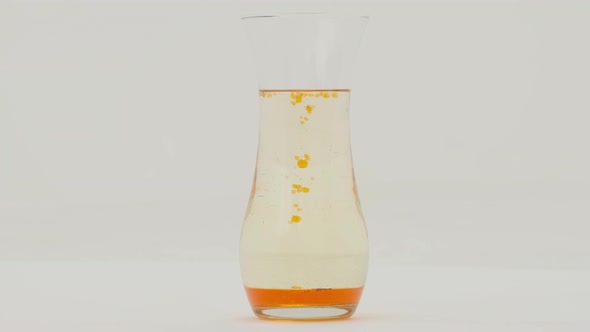 Orange lava lamp effect in a glass vase on white background