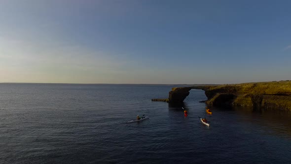 Tourists kayak through a natural arch, Peninsula Valdes, Chubut Province, Argentina