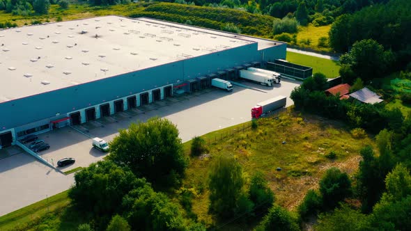 Logistics park with a warehouse - loading hub. Semi-trucks with freight trailers standing at the ram