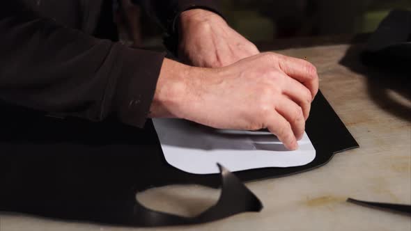 Skinner Is Circling Cartoon Blank on a Piece of Black Skin for Making Goods