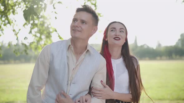 Portrait of Cheerful Loving Young Couple Standing in Sunlight, Talking and Laughing. Happy Caucasian