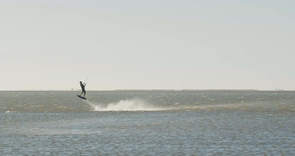 Kitesurfing tricks performed by a man in the ocean, high jump, 4k
