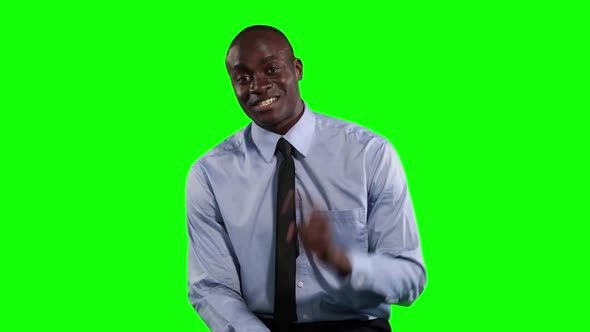 an African American man in suit talking in green background