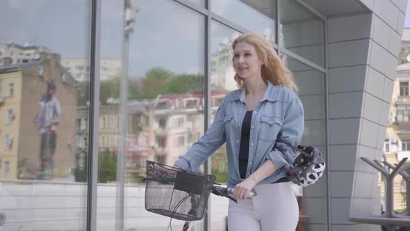 Portrait Cute Young Slim Attractive Blond Woman in White Jeans Leading Her Bicycle Near the Shop