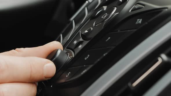 Male Hand Adjust the Volume or the Tuning of the Car Radio