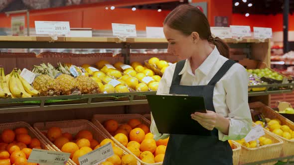 Young Store Manager Examines Condition of Products Closeup