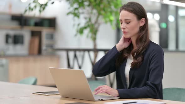 Businesswoman with Neck Pain Using Laptop at Work