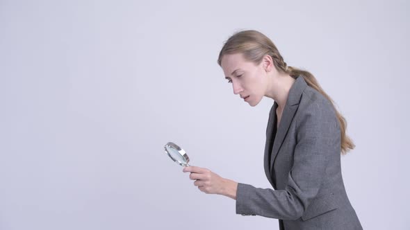 Young Blonde Businesswoman Using Magnifying Glass