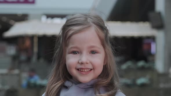 Little Beautiful Girl Looks at the Camera and Smiles