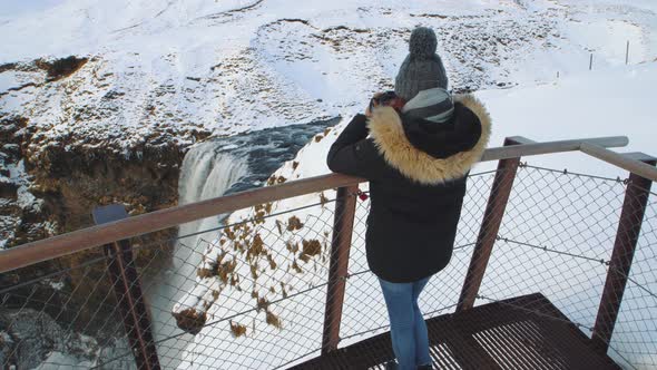 Woman Traveler on the Top of Famous Waterfall Skogafoss in Iceland