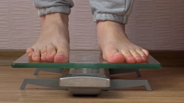 Women's Feet Stand on the Scales and Check Their Kilograms Front View